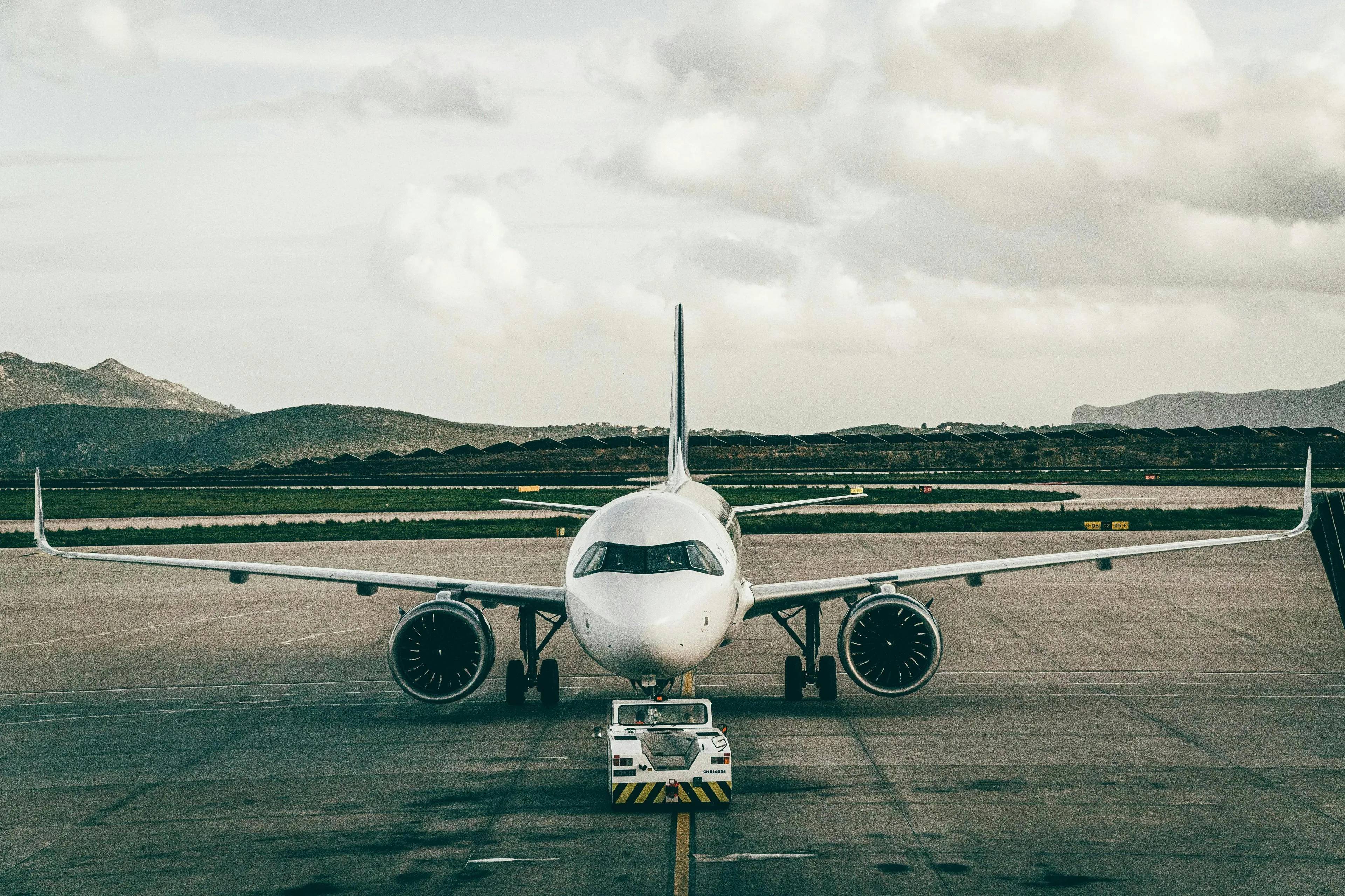 A passenger jet on a Pacific runway under a bright sky