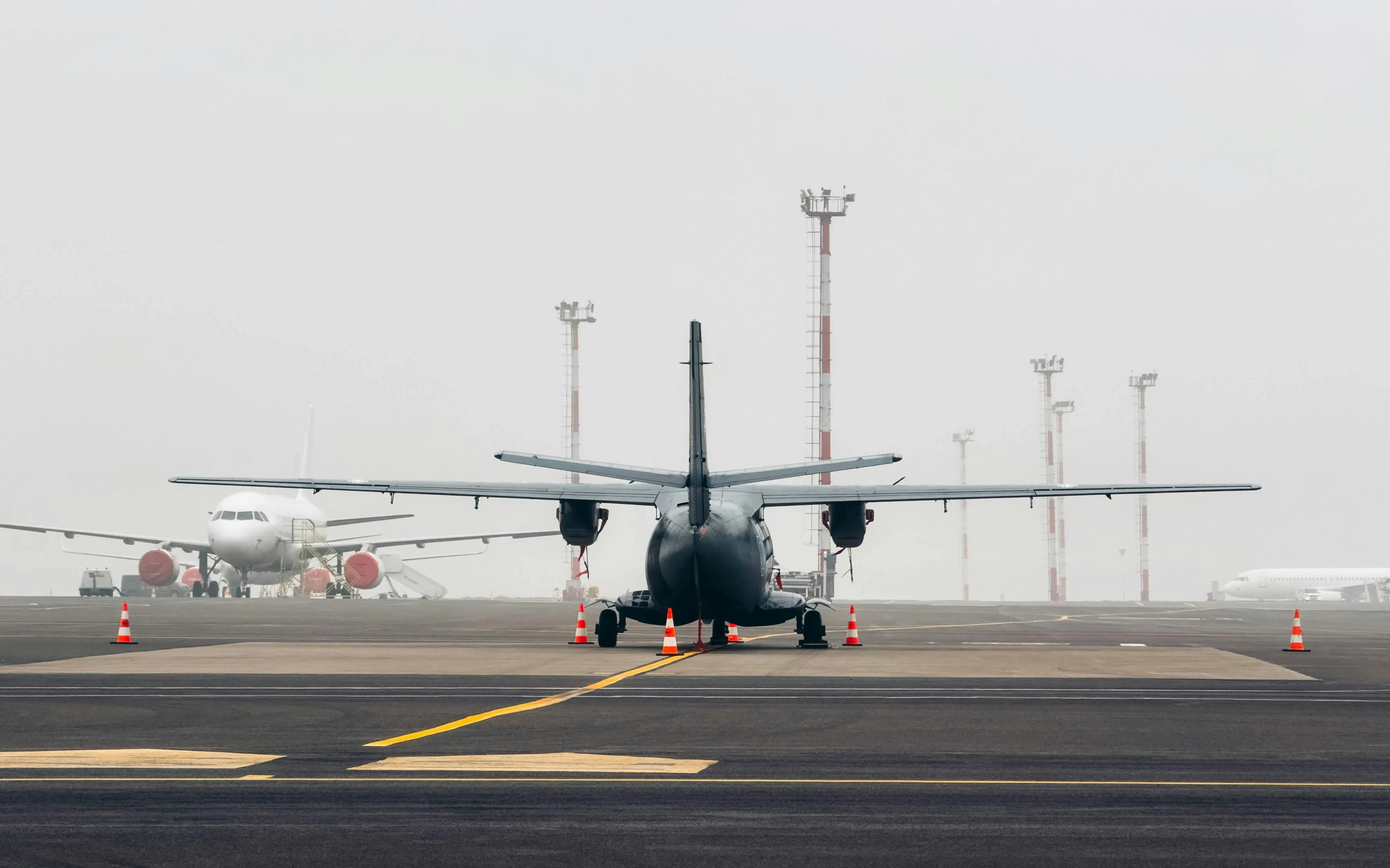A transport aircraft taking off into a pale sky
